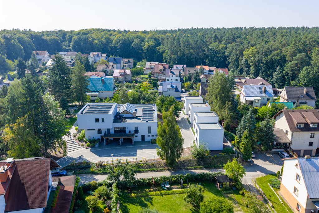 Apartamenty PATIO w Łagowie widziane z drona — nowoczesne białe budynki otoczone zielenią